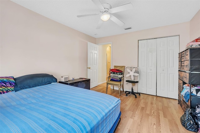 bedroom featuring ceiling fan, light hardwood / wood-style floors, and a closet