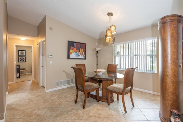 dining area with lofted ceiling and light tile patterned floors