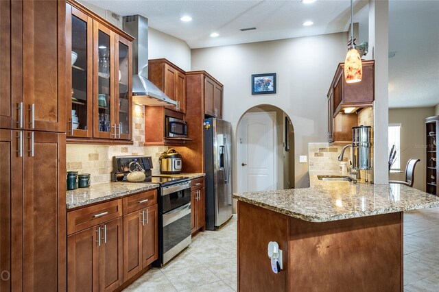 kitchen featuring light tile patterned flooring, wall chimney range hood, backsplash, stainless steel appliances, and sink