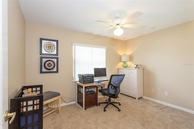 carpeted office featuring a textured ceiling and ceiling fan