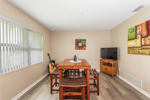 dining space with wood-type flooring