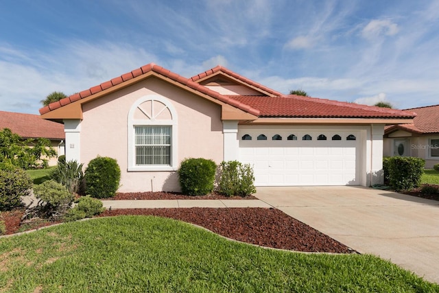 mediterranean / spanish-style house featuring a garage and a front yard