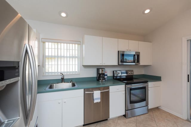 kitchen with sink, light tile patterned floors, stainless steel appliances, and white cabinets