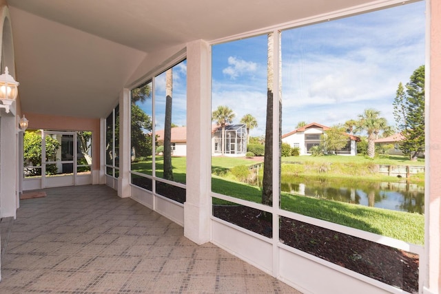 unfurnished sunroom with vaulted ceiling and a water view