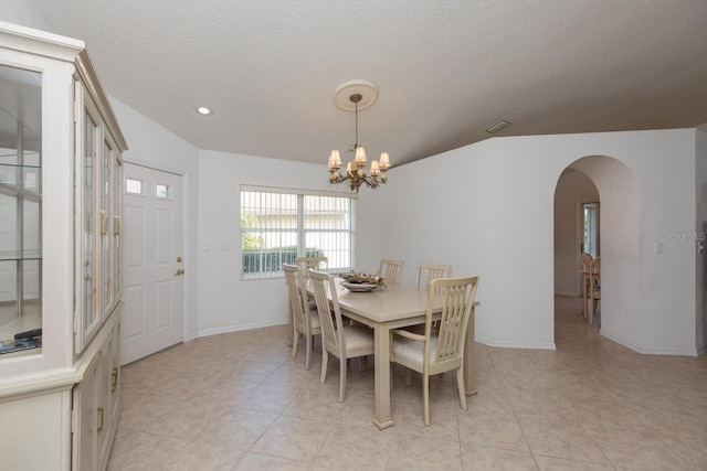 tiled dining room with a chandelier and a textured ceiling