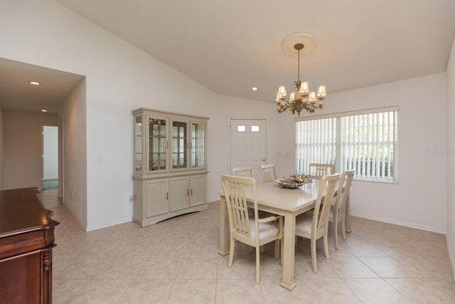 tiled dining space featuring vaulted ceiling and a chandelier