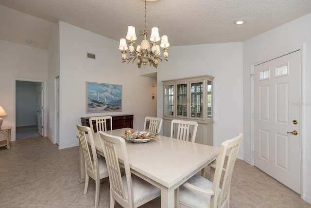 dining space featuring light tile patterned floors, a chandelier, and a textured ceiling