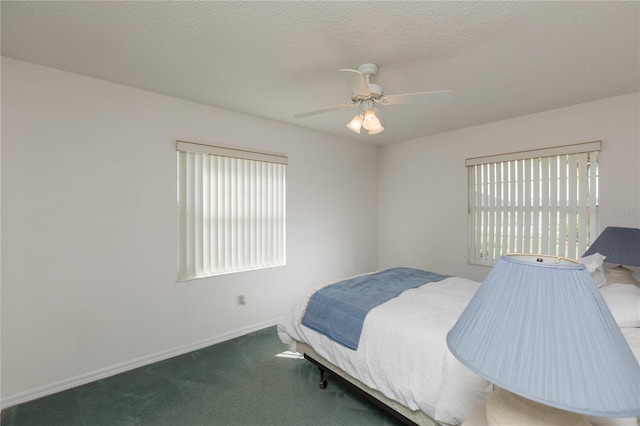 bedroom with multiple windows, ceiling fan, carpet, and a textured ceiling