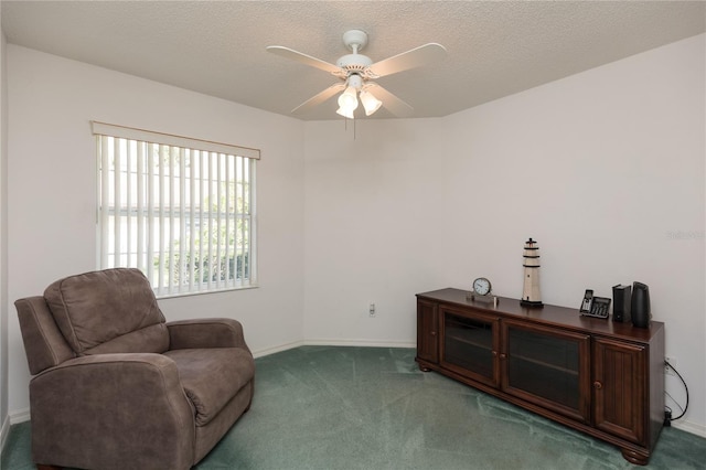 sitting room featuring ceiling fan, carpet flooring, and a textured ceiling