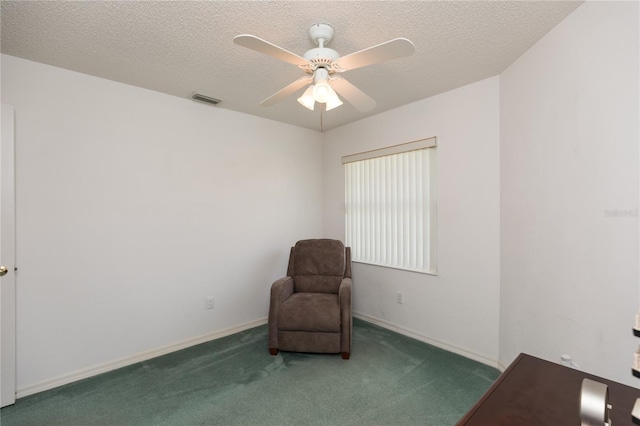 living area featuring a textured ceiling, ceiling fan, and dark colored carpet