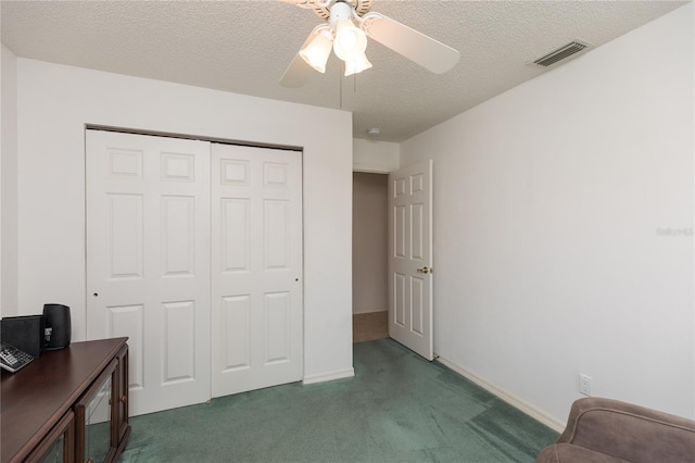 bedroom featuring ceiling fan, a textured ceiling, a closet, and dark colored carpet