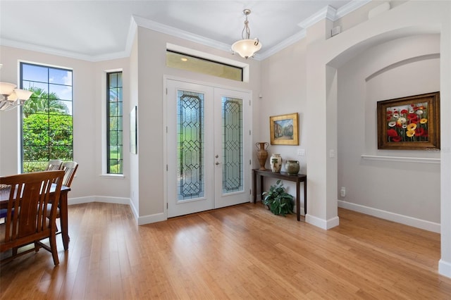 entryway featuring ornamental molding, light wood-type flooring, and french doors