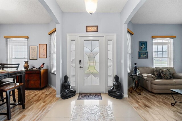 entryway featuring a textured ceiling and light hardwood / wood-style floors