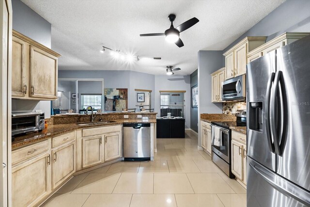 kitchen with appliances with stainless steel finishes, track lighting, sink, light tile patterned flooring, and ceiling fan