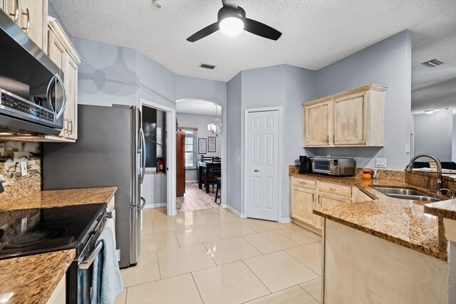 kitchen featuring light tile patterned flooring, a textured ceiling, ceiling fan, range with electric cooktop, and sink