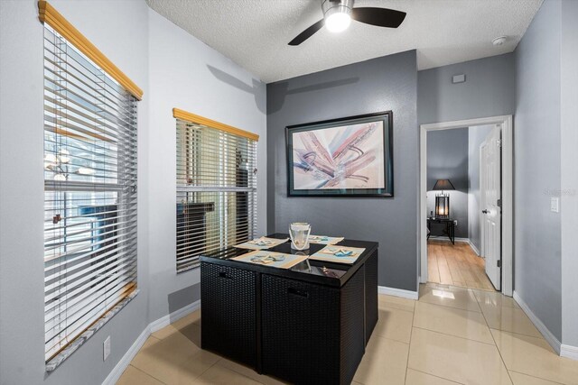 tiled home office with a textured ceiling and ceiling fan