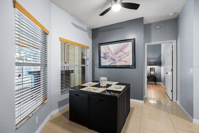 home office featuring ceiling fan, light tile patterned floors, plenty of natural light, and a textured ceiling