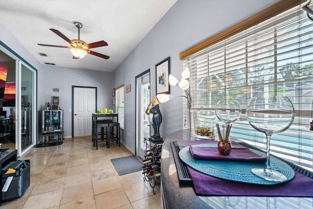 interior space featuring a textured ceiling, ceiling fan, and light tile patterned floors