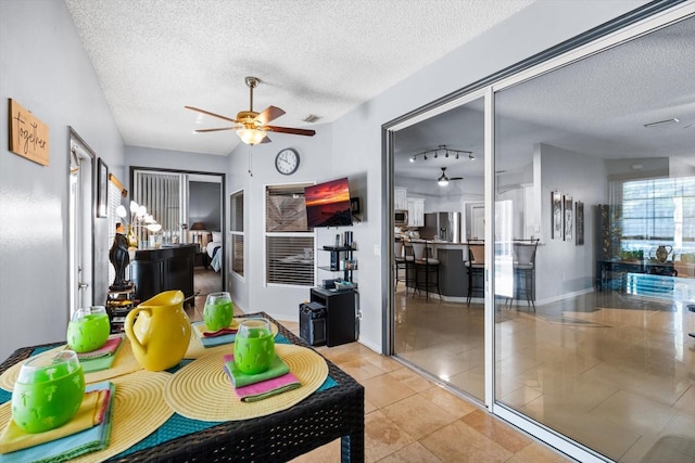 interior space with a textured ceiling and ceiling fan