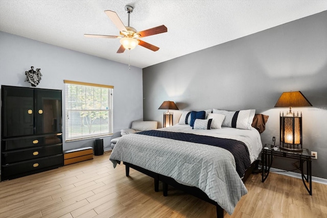 bedroom featuring light hardwood / wood-style floors, a textured ceiling, and ceiling fan