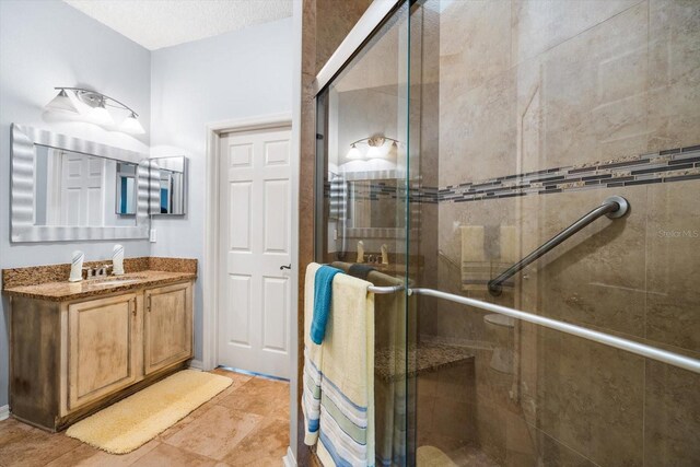 bathroom with vanity, walk in shower, and tile patterned flooring