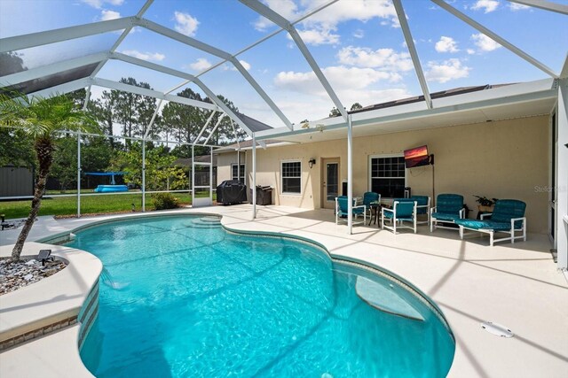 view of pool with a patio area and glass enclosure