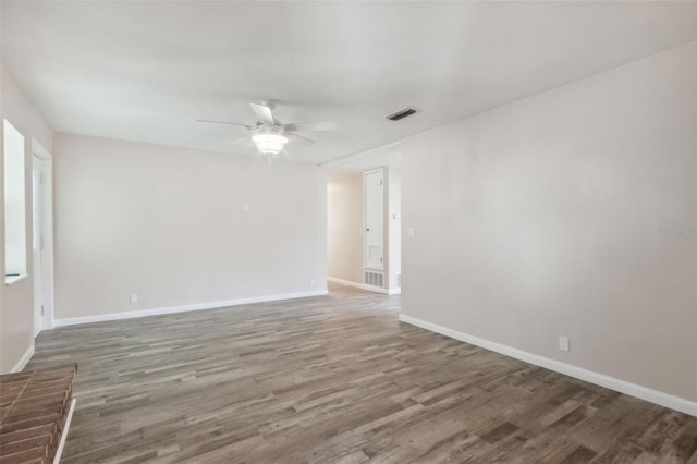 empty room with dark hardwood / wood-style floors and ceiling fan