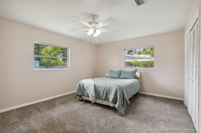 carpeted bedroom with a closet and ceiling fan