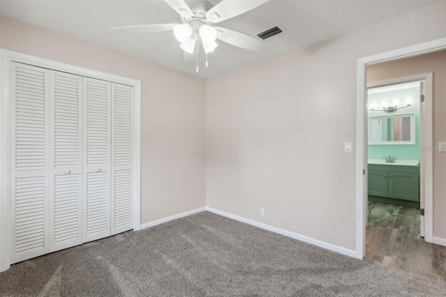 unfurnished bedroom with a closet, ceiling fan, carpet flooring, and sink