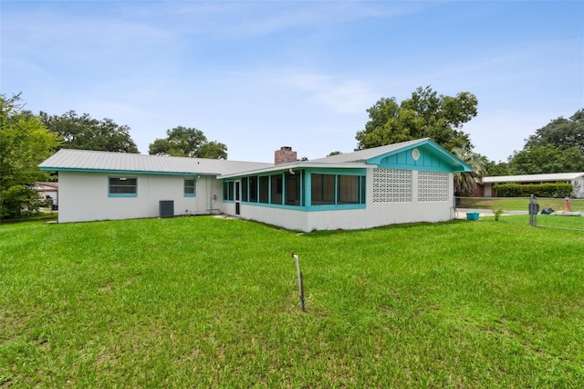 back of property featuring a sunroom, central air condition unit, and a yard