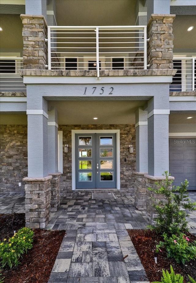 view of exterior entry featuring french doors and a balcony