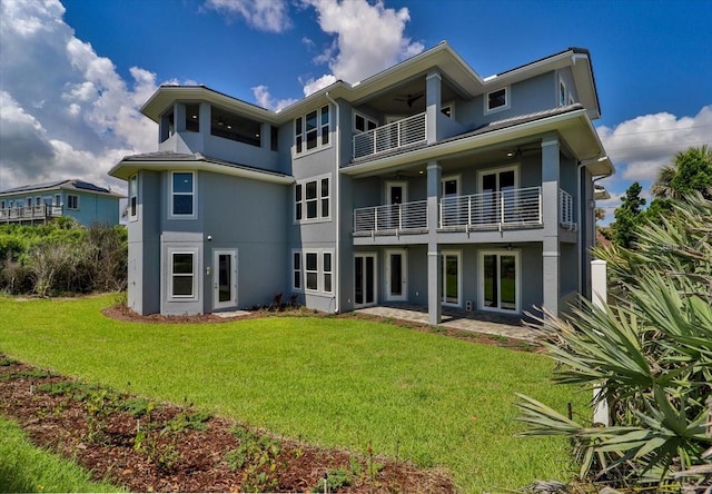 rear view of property with a balcony and a yard