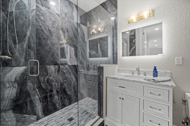 bathroom featuring an enclosed shower, vanity, and toilet