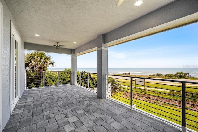 view of patio with a water view, a balcony, and ceiling fan