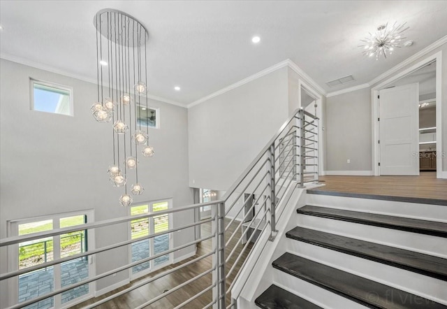 stairway with hardwood / wood-style flooring, ornamental molding, and a wealth of natural light