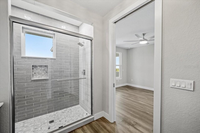 bathroom featuring hardwood / wood-style flooring, ceiling fan, and walk in shower