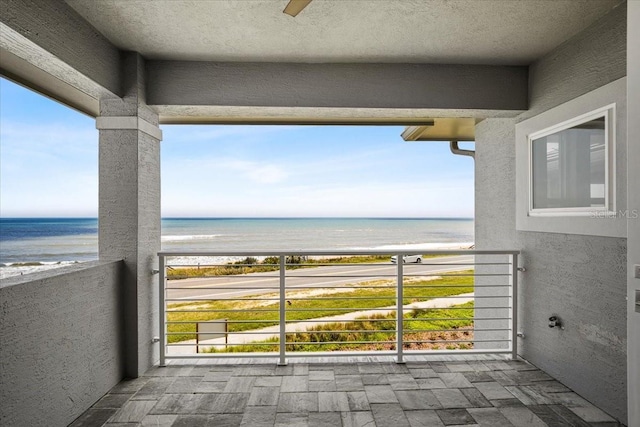 balcony featuring a beach view and a water view