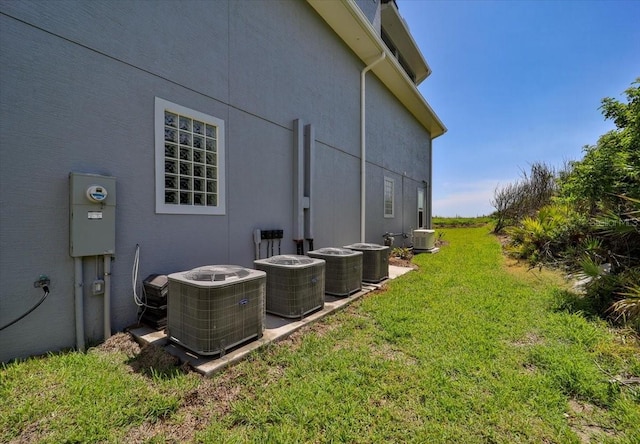 view of side of home featuring a lawn and central air condition unit