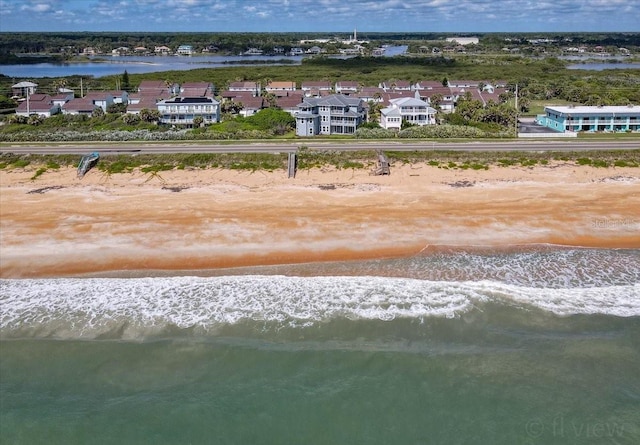 birds eye view of property with a water view and a beach view