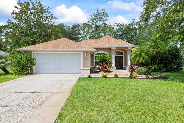 view of front of house featuring a garage and a front lawn