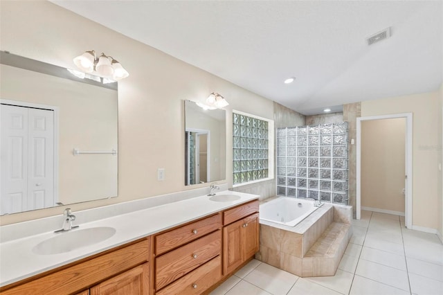 bathroom featuring dual vanity, tiled bath, and tile patterned floors