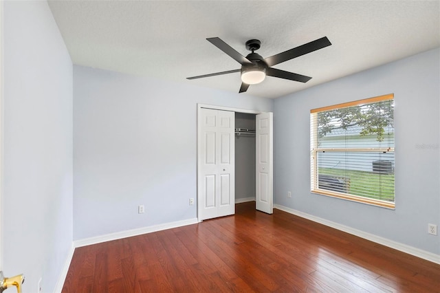 unfurnished bedroom featuring ceiling fan, hardwood / wood-style floors, and a closet