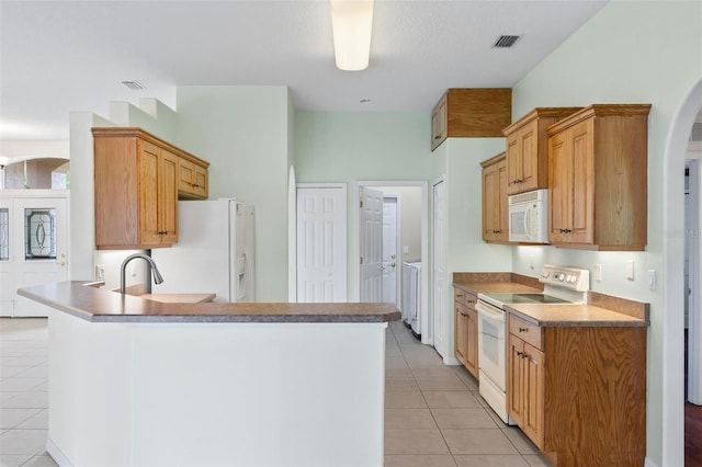 kitchen featuring sink, light tile patterned floors, and white appliances