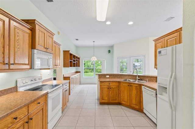 kitchen with white appliances, sink, kitchen peninsula, hanging light fixtures, and light tile patterned floors