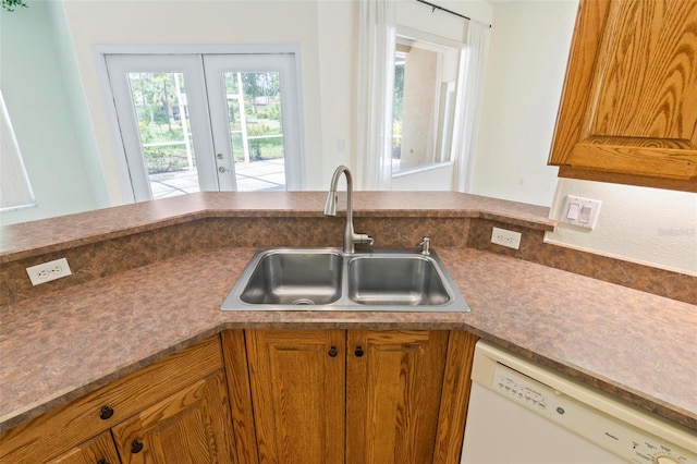 kitchen with white dishwasher, french doors, and sink