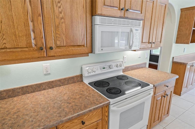 kitchen with white appliances and light tile patterned floors