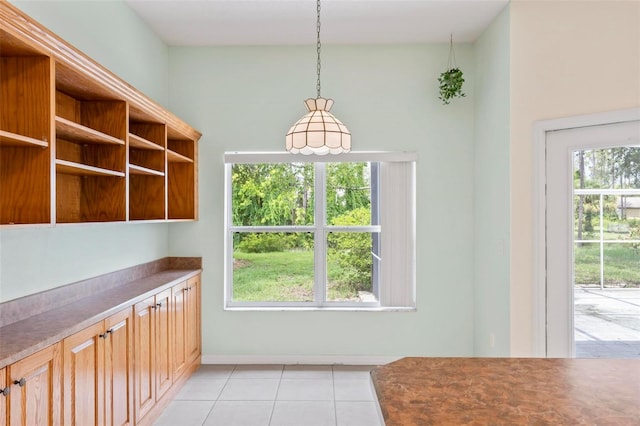 kitchen featuring light tile patterned floors, a wealth of natural light, and pendant lighting