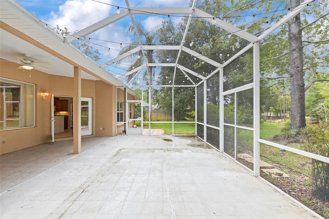 unfurnished sunroom with ceiling fan