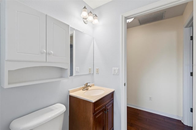 bathroom featuring toilet, hardwood / wood-style floors, and vanity