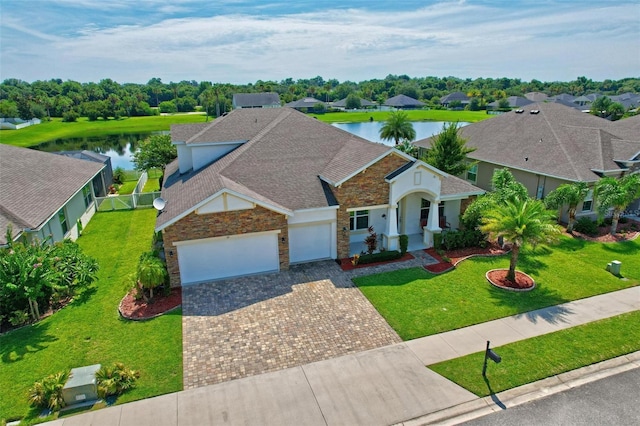 view of front of property featuring a garage, a water view, and a front yard